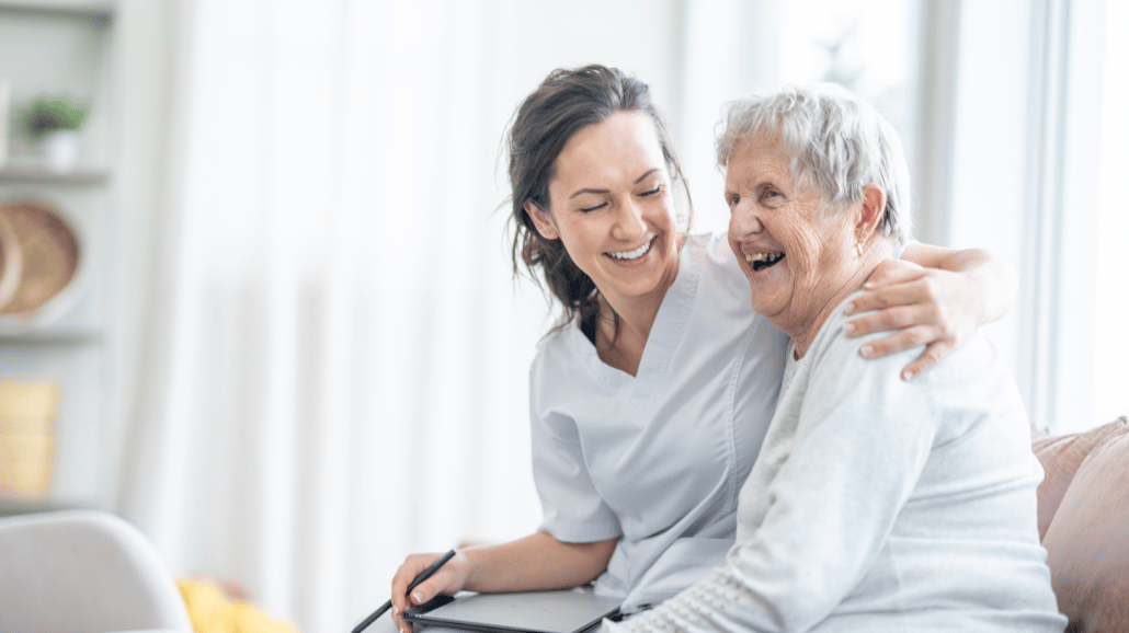 Caregiver with her arm around a senior patient
