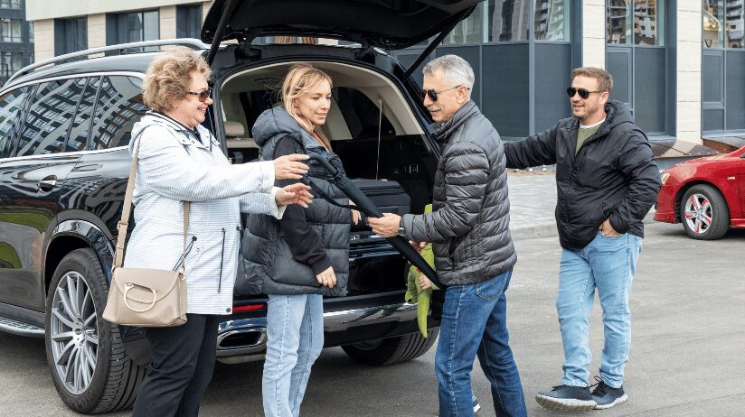 Multigenerational family at the airport unloading luggage