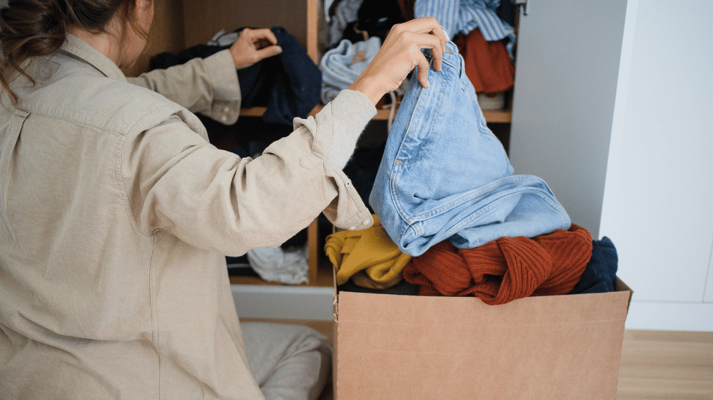 Woman decluttering clothes in her closet