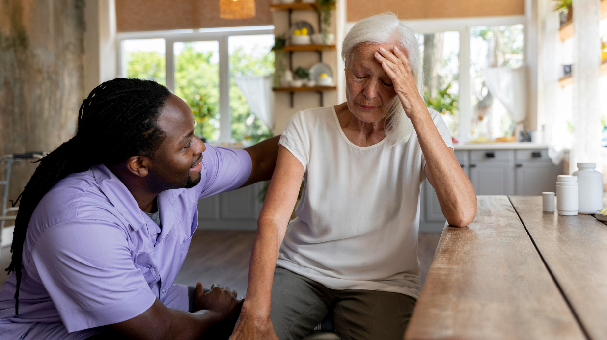 Senior woman with dementia sitting with a male caregiver