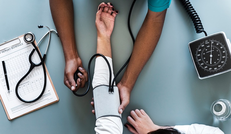 Nurse checking a woman's blood pressure