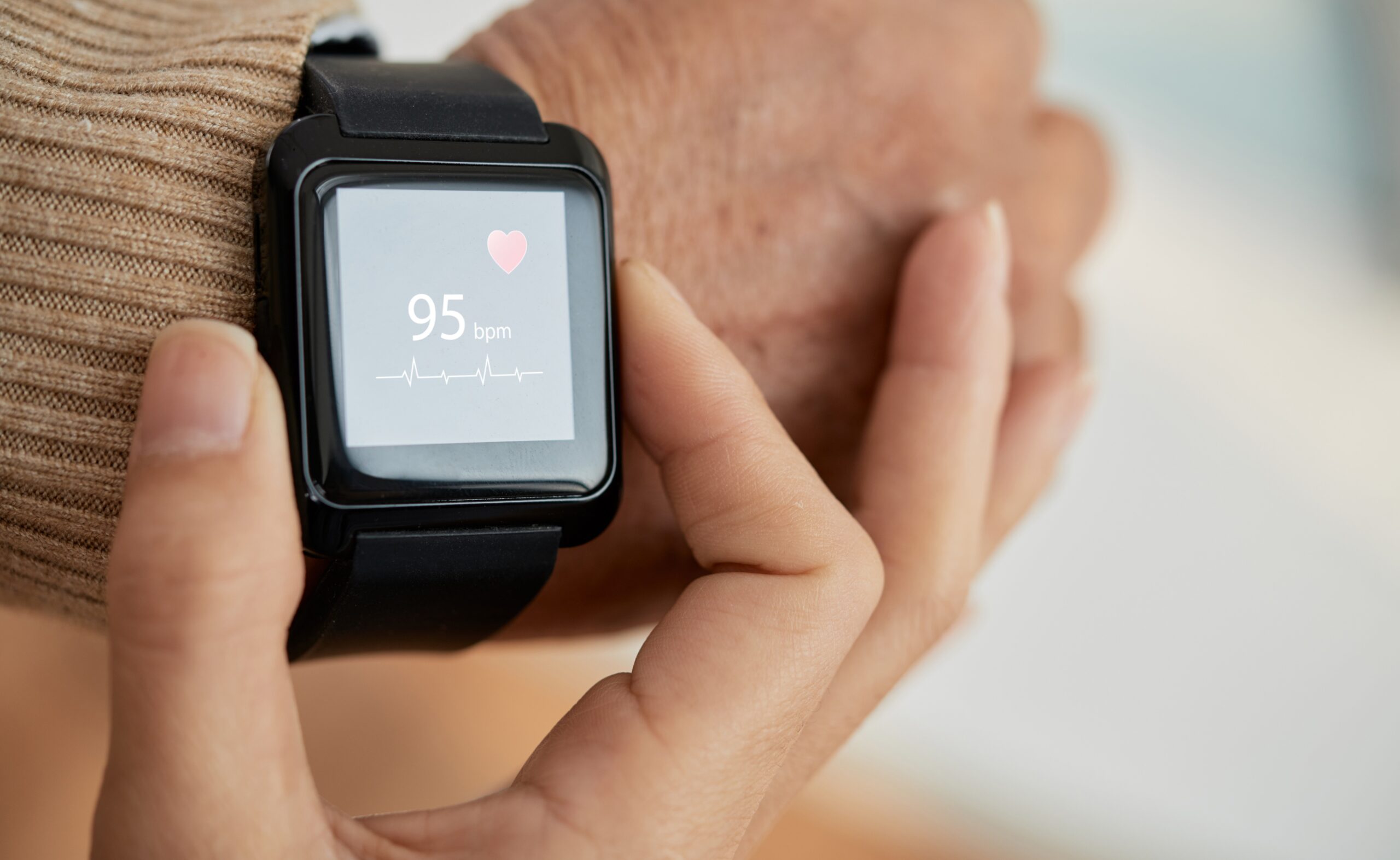 Woman checking pulse on a smart watch