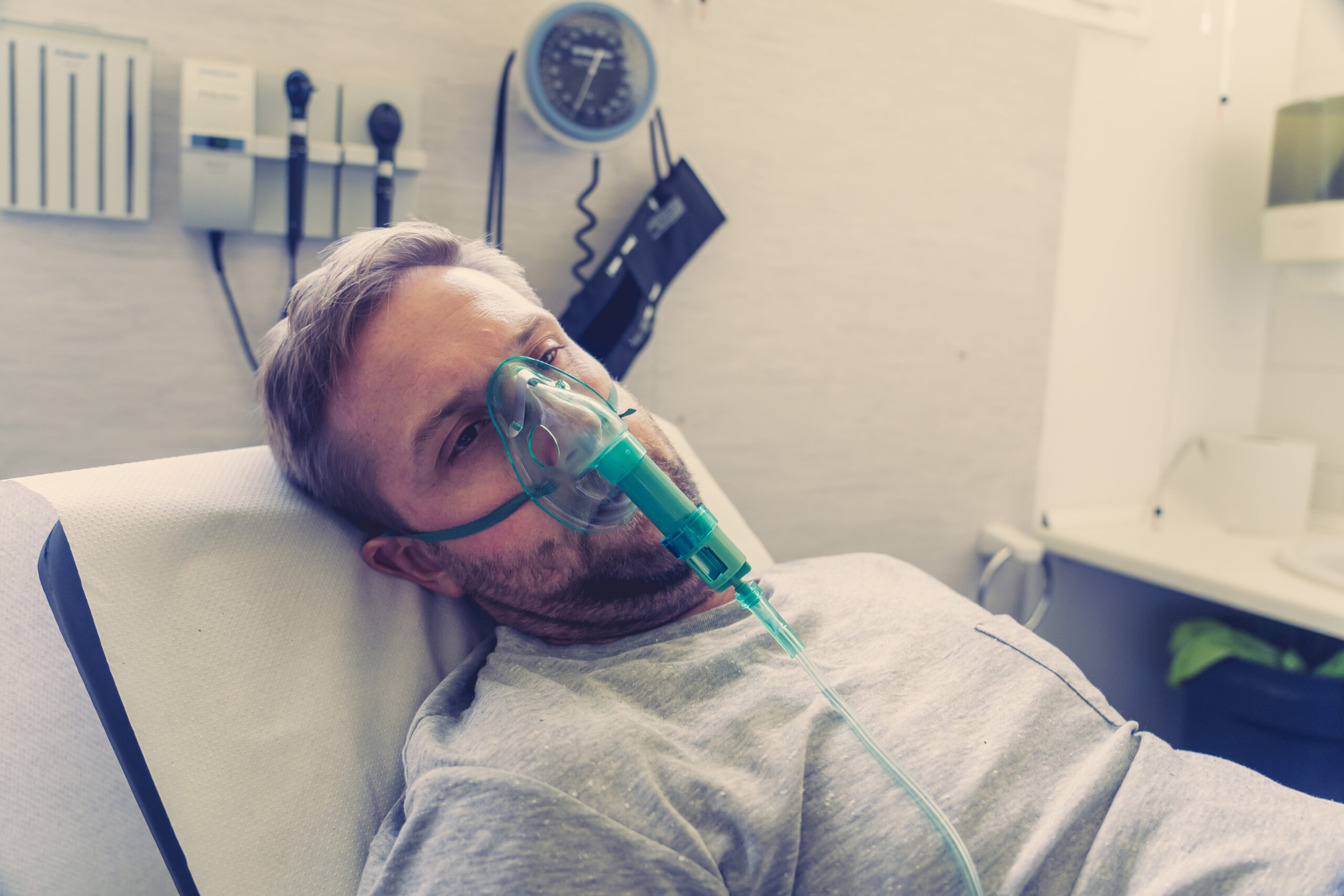 Sick man with oxygen mask in emergency room at hospital Sick man with oxygen mask in emergency room at hospital