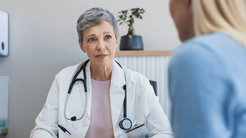 Woman talking with a mature female doctor