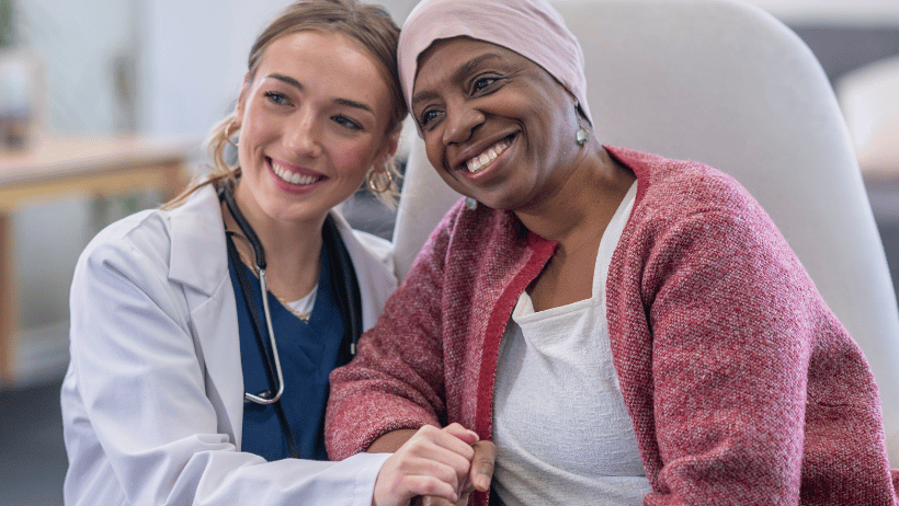 Blog20Covers20-202023-03-21T101911.817 Nurse smiling and holding the hand of a female cancer patient