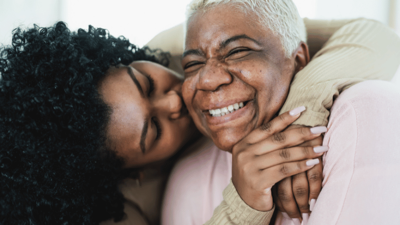 Senior mother and adult child hugging and smiling