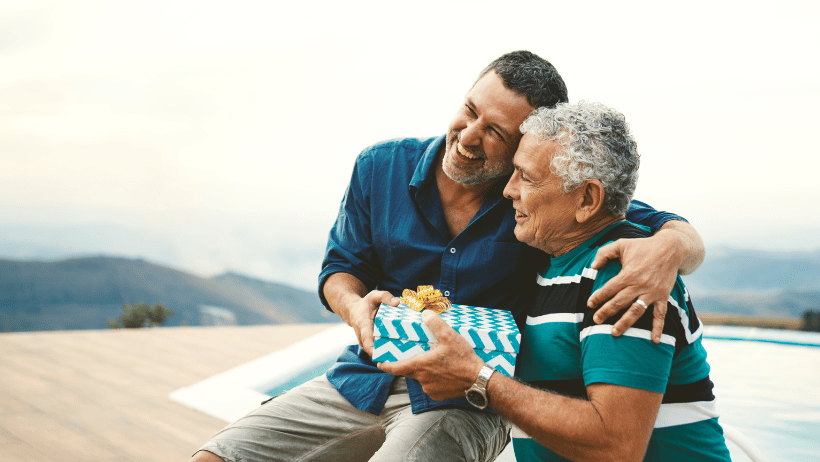 Adult son giving a present to elderly father