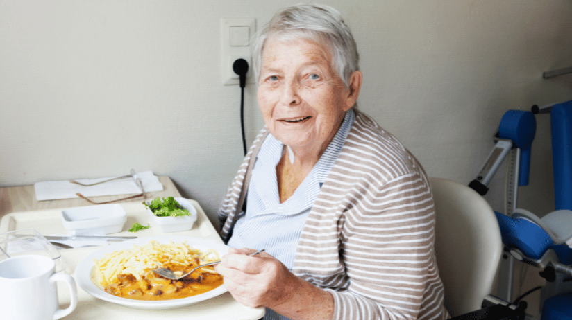 Blog20Covers20-202023-08-09T123816.165 Senior woman eating rice and curry at a table