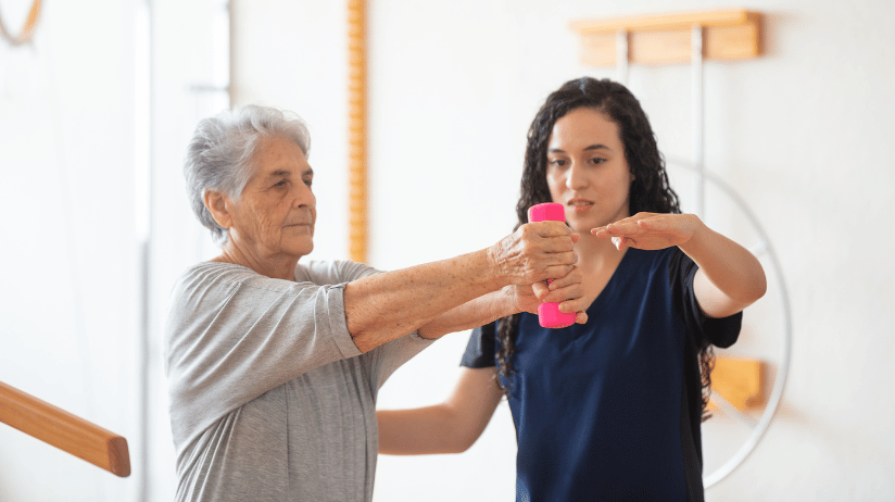 Blog20Covers20-202024-01-08T151853.489 Caregiver helping a senior woman lift small weights