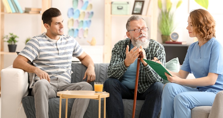 Caregiver with senior man and his son at home