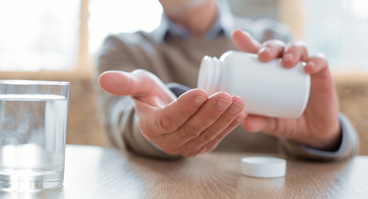 Medication For Heart. Close Up Of Attractive Senior Male Hands C Medication for heart. Close up of attractive senior male hands carrying bottle filled with medication