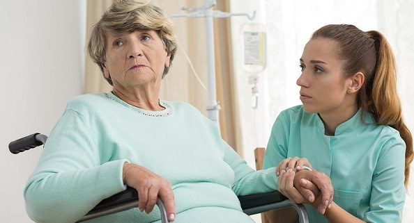 Grumpy senior woman with her caregiver