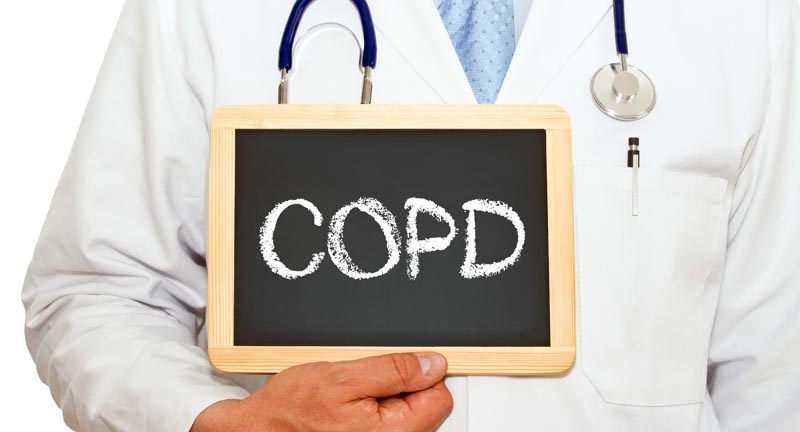 Doctor_with_COPD_on_Chalkboard-LR Doctor holding a sign with the letters COPD