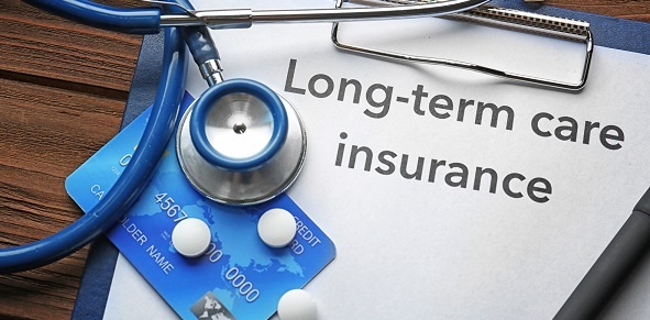 Credit card and stethoscope on a clip board that reads "long-term care insurance"