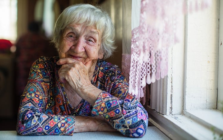Portrait of elderly woman sitting by a window