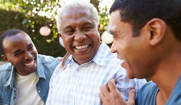 Senior man talking outdoors with his adult sons