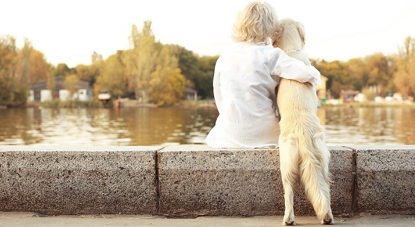 Senior woman holding a dog outside