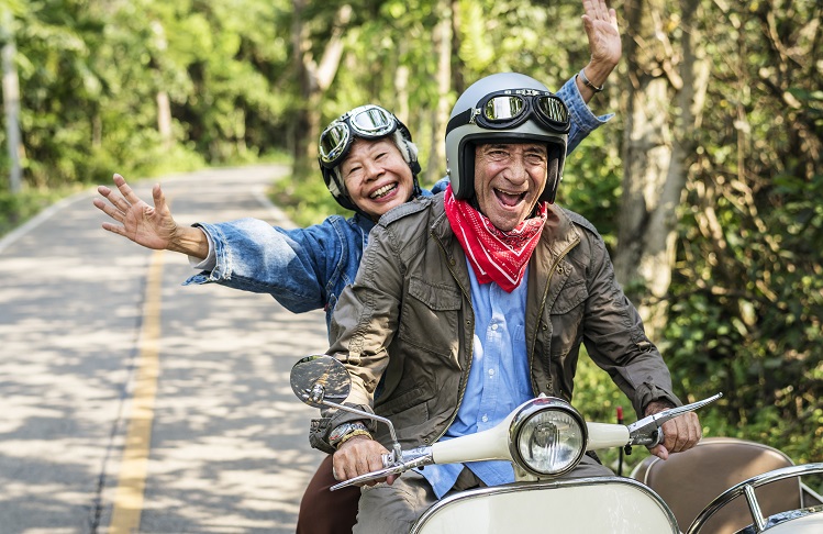 Senior couple riding a classic scooter