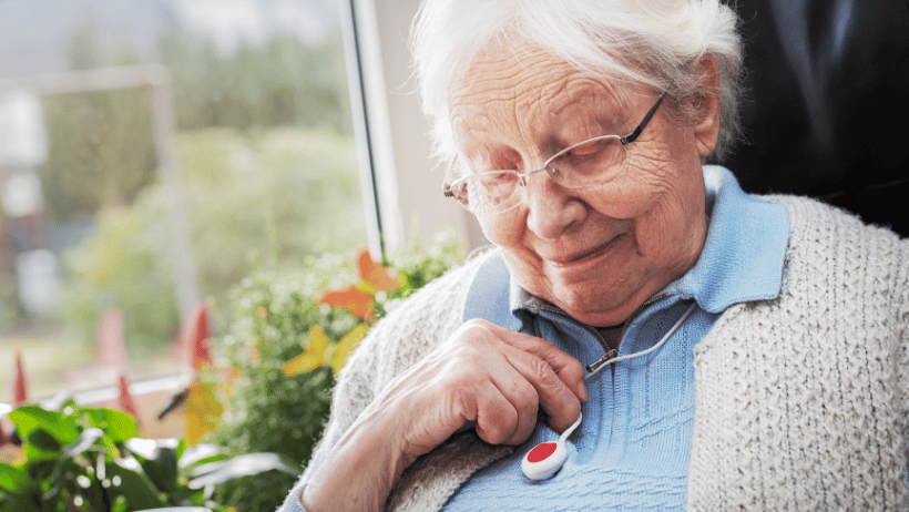 Senior20holding20medical20alert20device Senior woman sitting by a window and holding a medical alert device