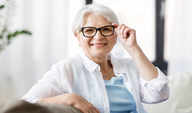 Senior woman holding glasses and smiling