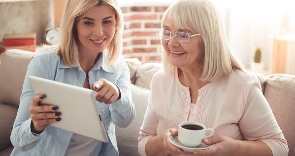 Tablet-Mother-And-Daughter-LR Adult daughter showing her elderly mom something on a tablet