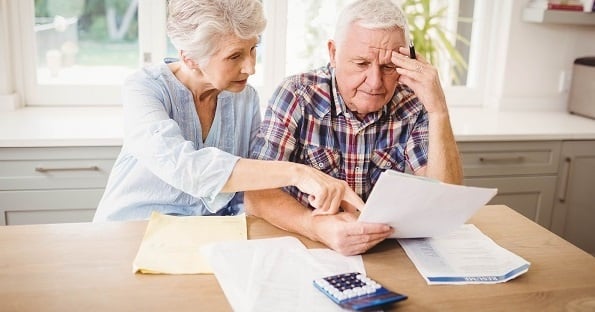 Elderly couple reviewing finances and looking stressed