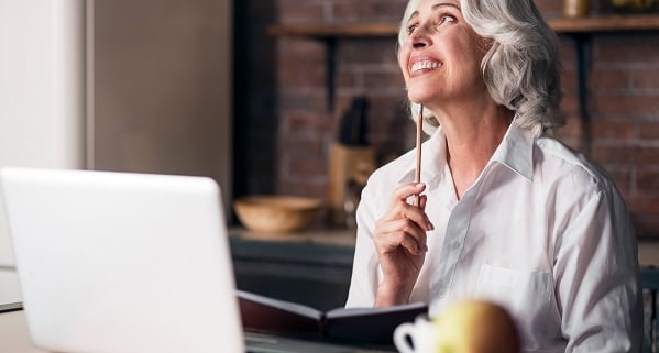 Women_thinking_pencil-LR Senior woman smiling confidently behind a computer