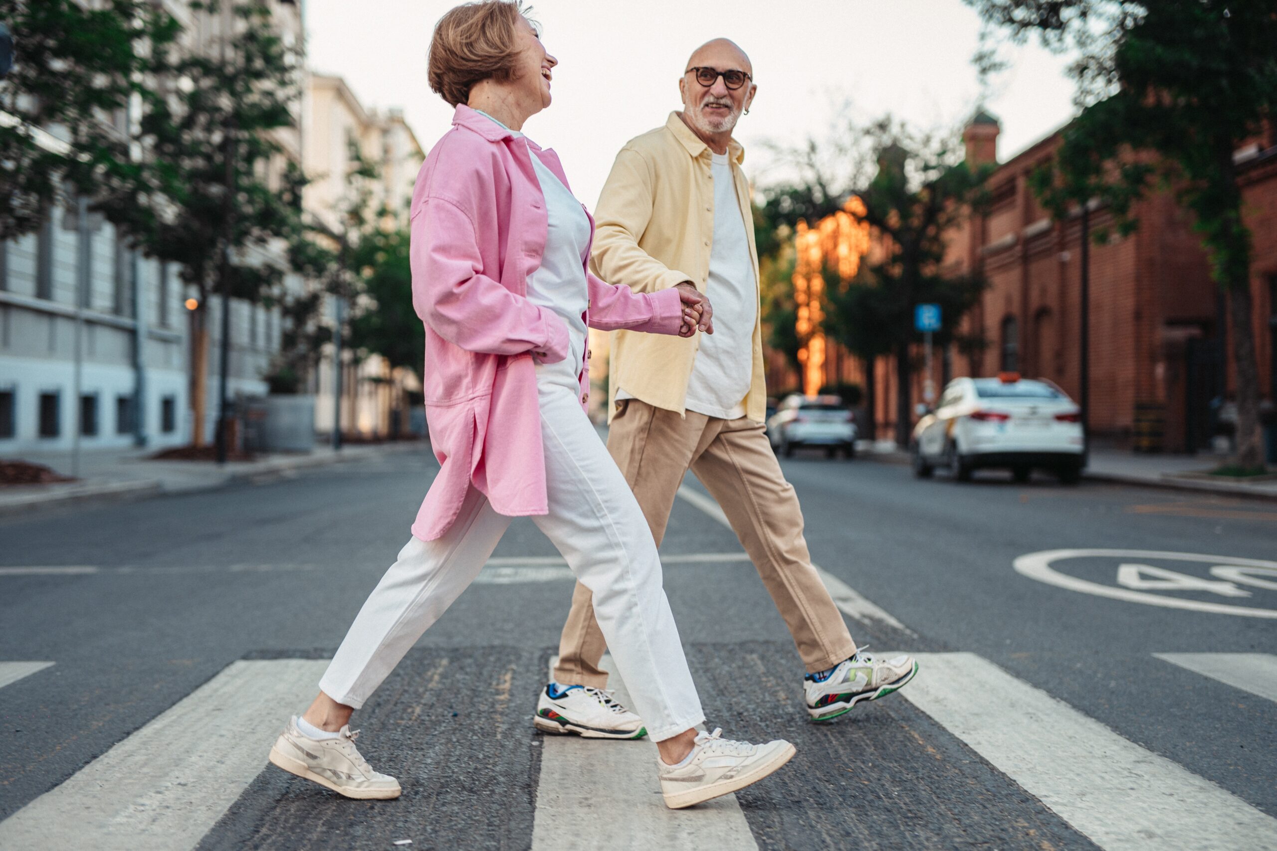 Senior couple holding hands and crossing the street
