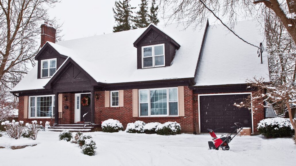 Senior's home covered in snow with a plow in the driveway