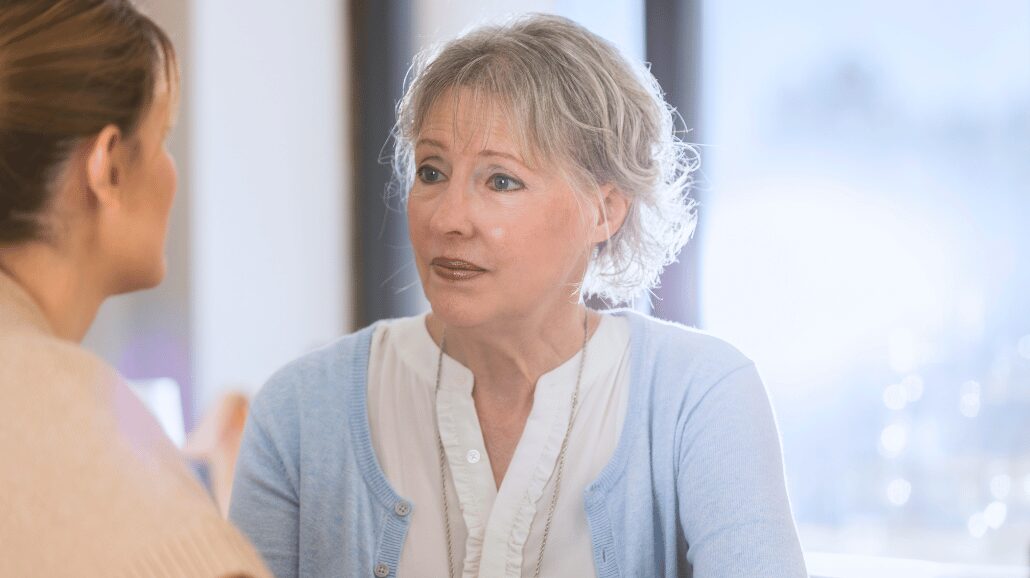 Adult daughter having a serious conversation with elderly mother