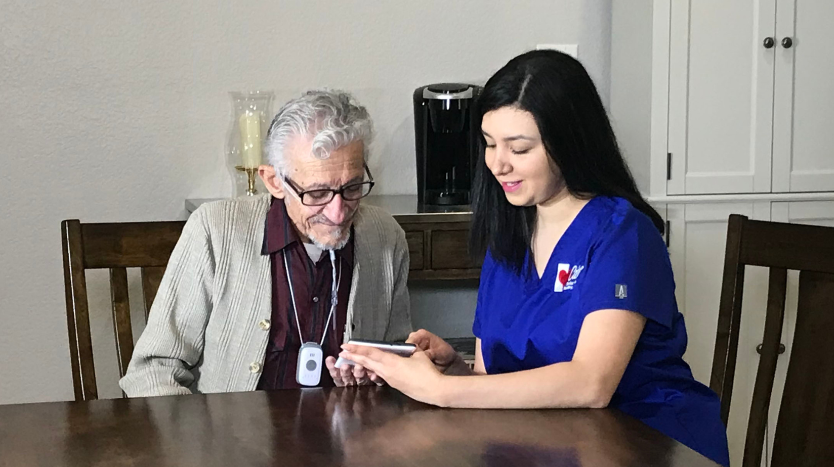 Caregiver working with a senior client on a tablet