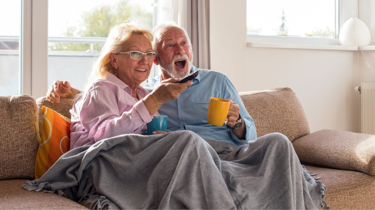 Blog Covers (43) Senior couple watching tv while snuggling on the couch