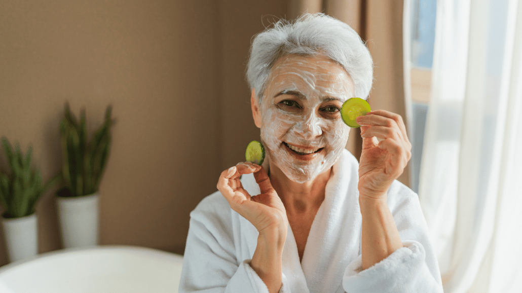 Blog Covers – 2025-05-14T125958.194 Senior woman with a face mask, holding cucumber slices and smiling