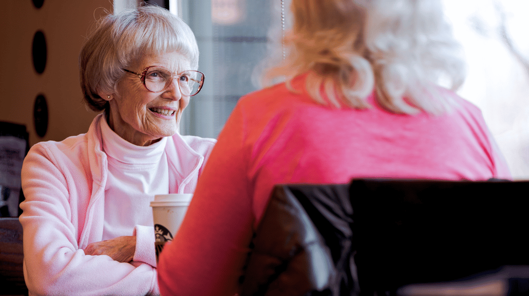 2 senior women talking at a coffee shop