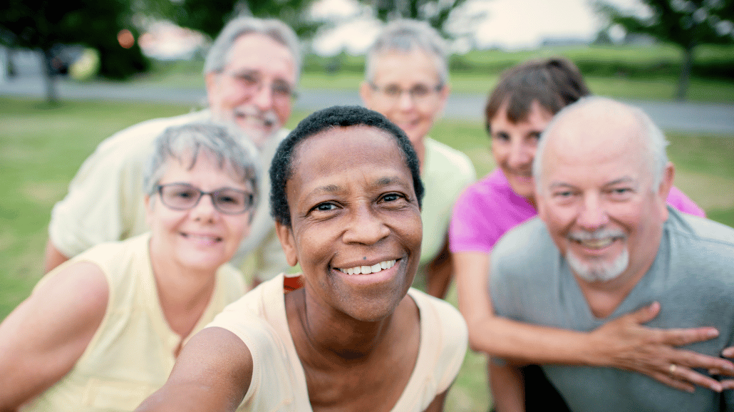 Senior citizens smiling while taking group photo outside