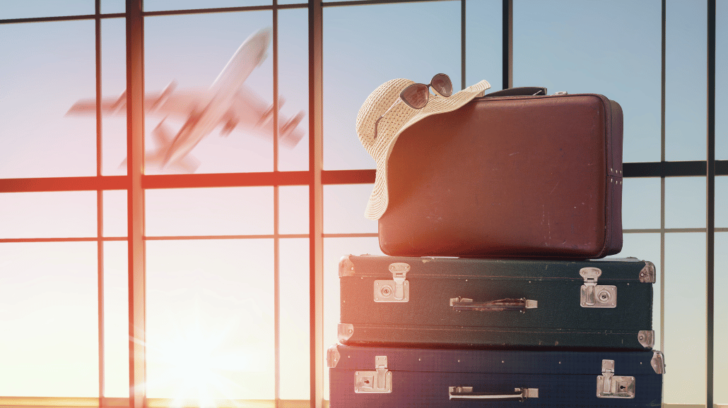 Set of luggage in an airport with a plane in the background