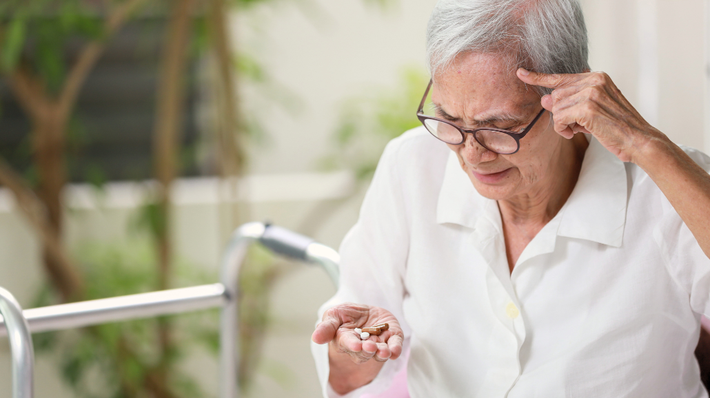 Confused senior holding medications in her hand