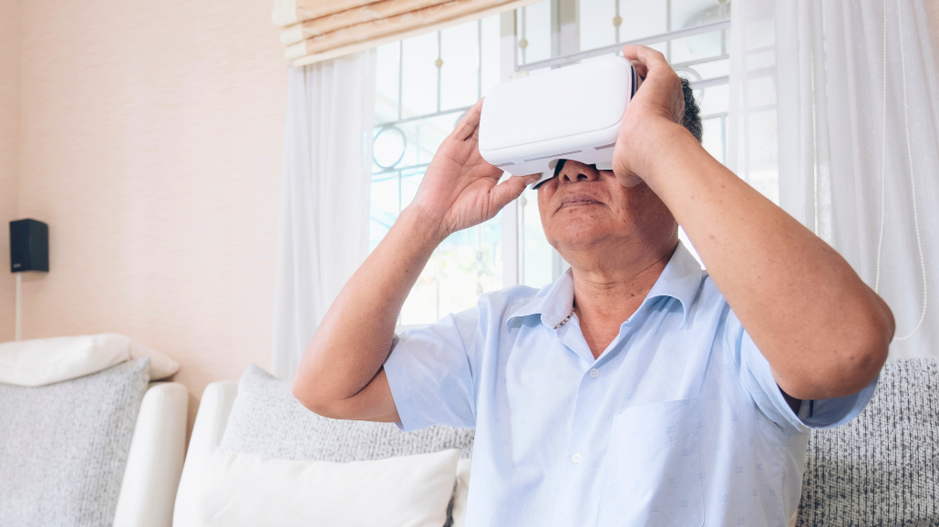 Senior man wearing a VR headset in his living room