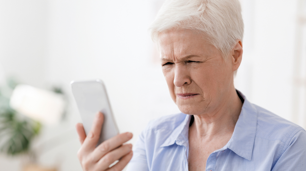 Senior woman squinting to look at her phone