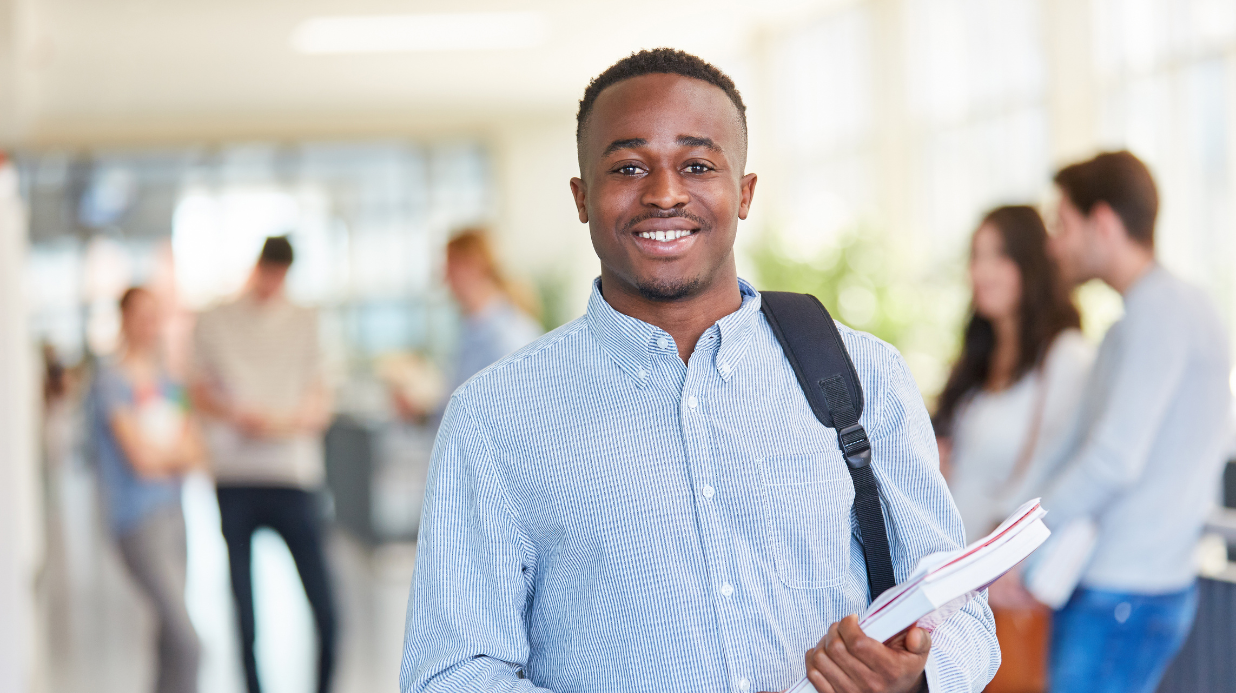 Black college student wearing backpack and smiling