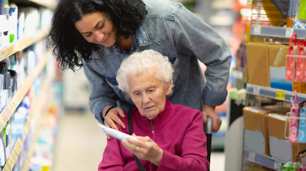 Caregiver shopping with a senior at the grocery store