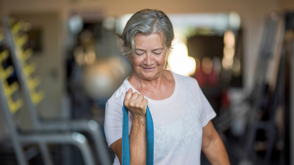 Senior woman doing arm exercises with a resistance band