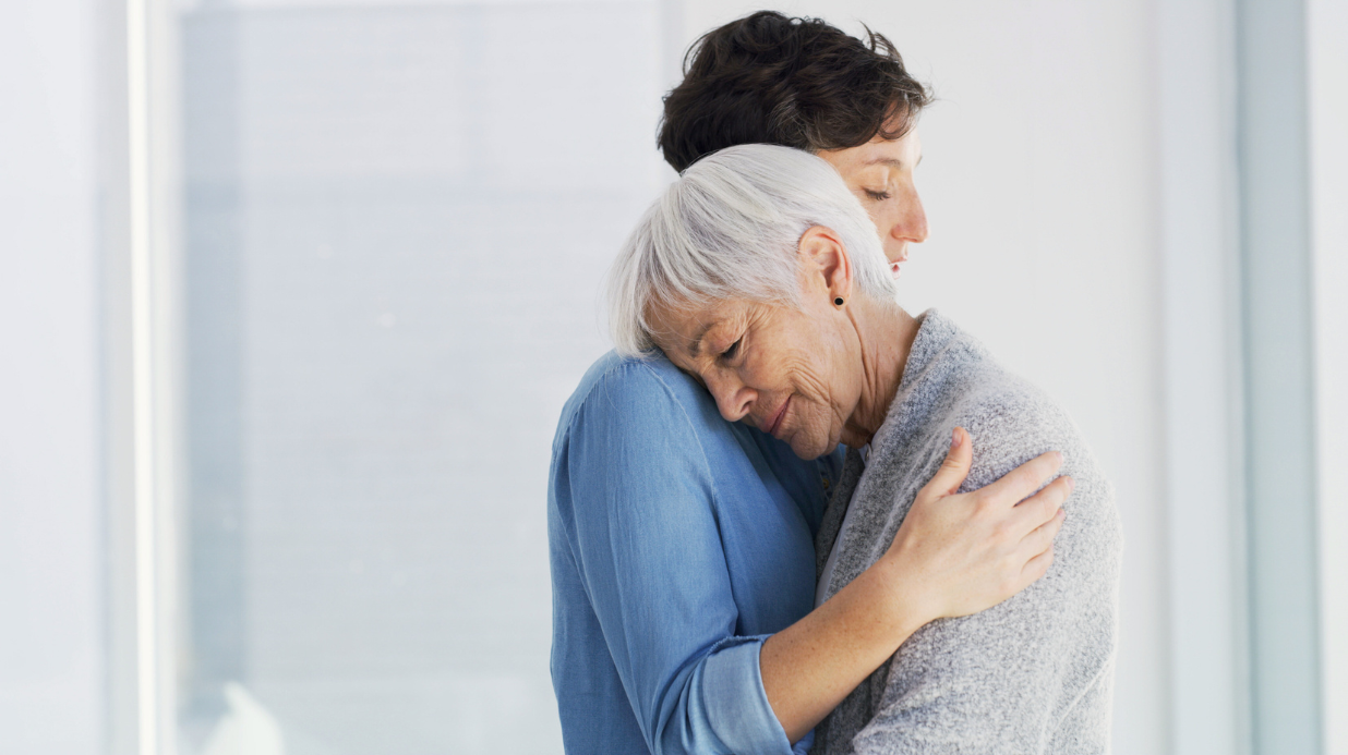 Adult woman hugging her senior mom