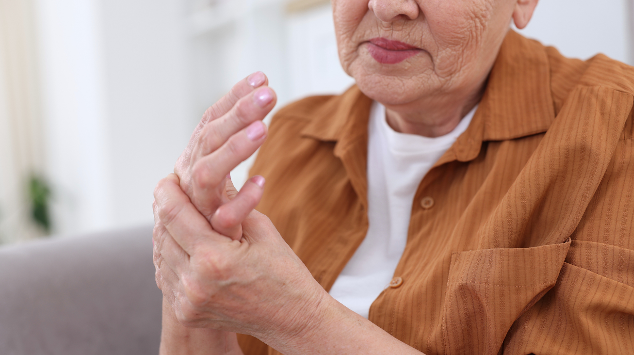 Senior woman holding a painful hand with arthritis
